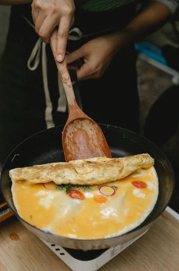 Man flipping over an omelet with a spatula 