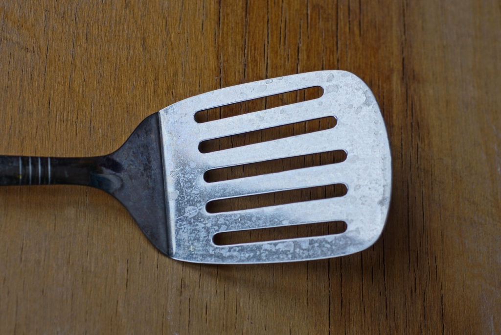 Metal spatula on the wooden table top 