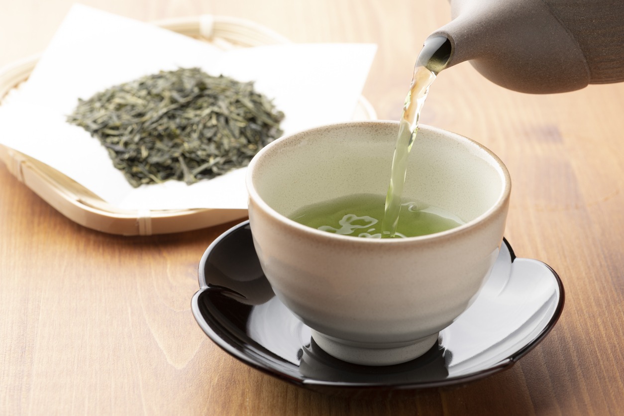 Warm green tea on a wooden table