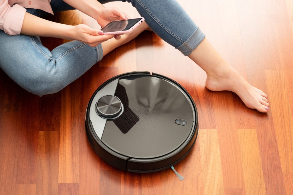 Woman controlling the robot mop with her smartphone