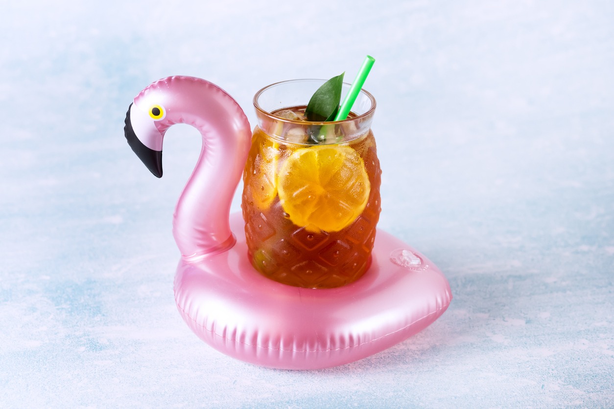 a glass of iced tea on a pink flamingo coaster