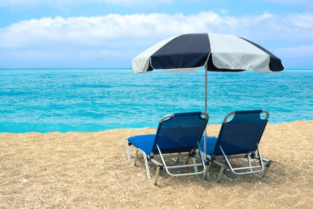 beach umbrella with empty chairs