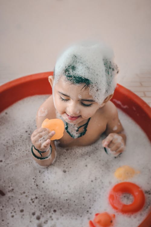 child playing with toys while bathing