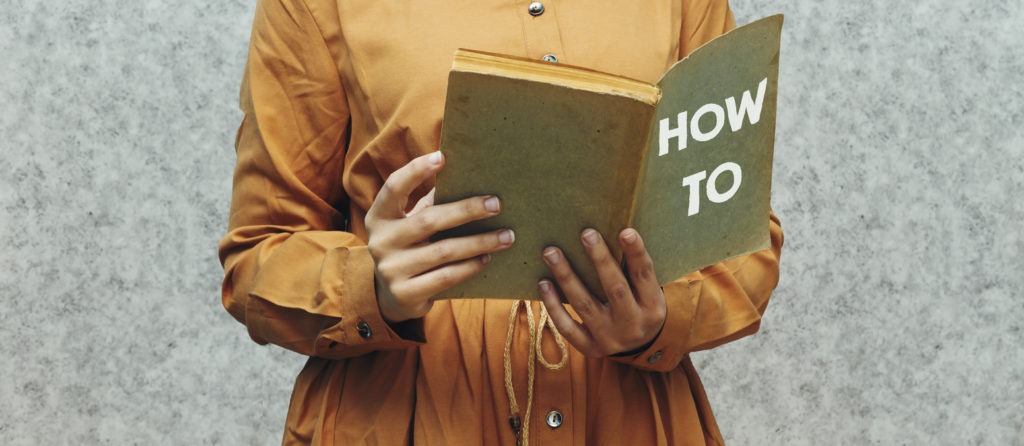 close up woman holding a book with how to concept