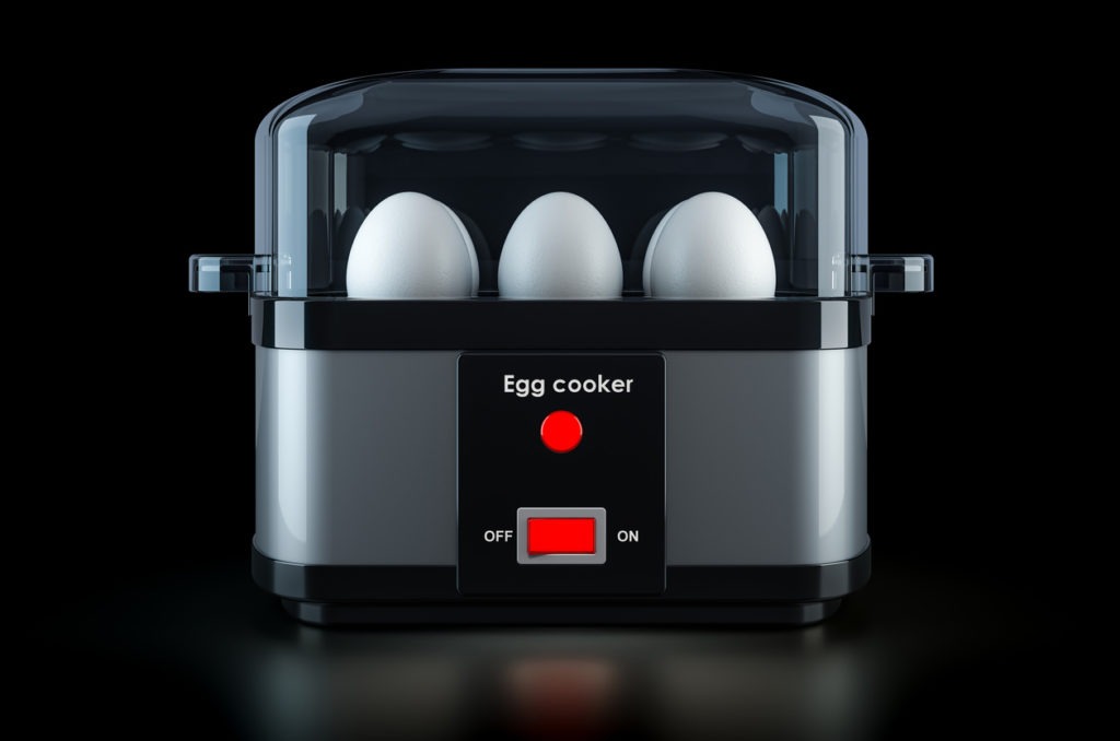 Egg cooker or egg boiler with eggs on black background
