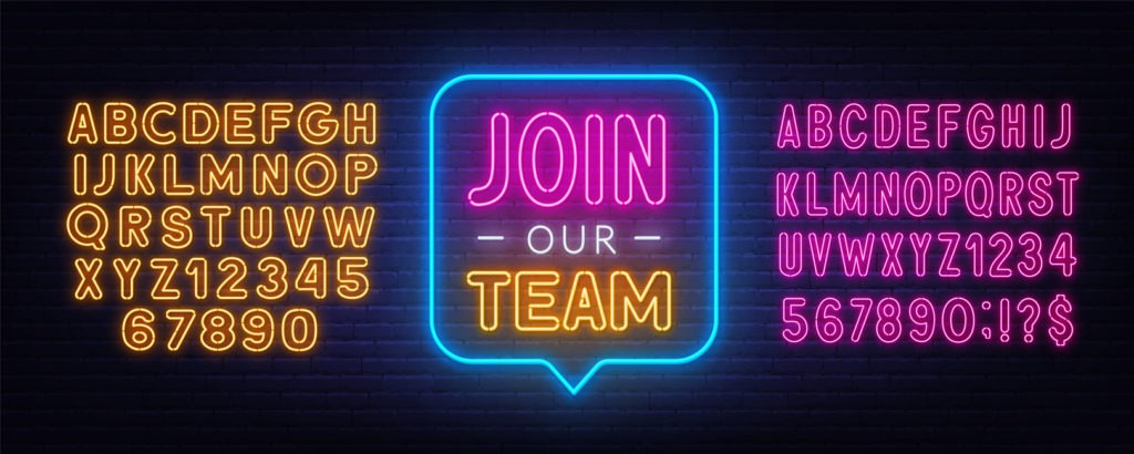 Join Our Team neon sign on a brick background.