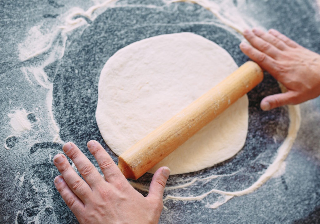 Knead the dough with the ingredients. The chef prepares pizza.