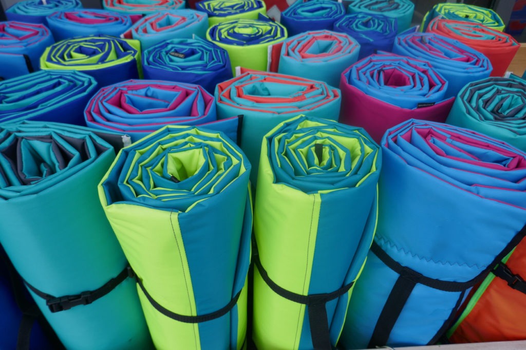 Rolled colorful air mattresses for camping and trekking holidays