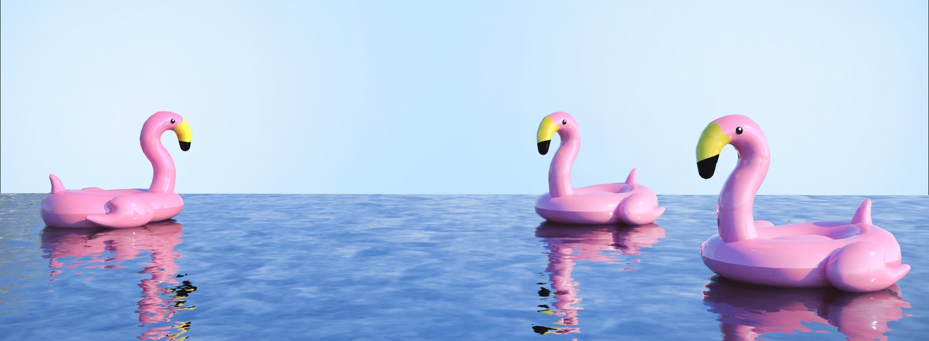 three pink flamingo inflatable floats on a pool