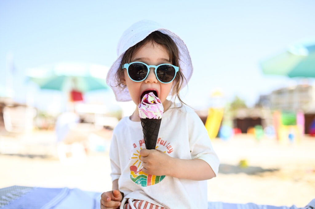 toddler eating ice cream at the beach