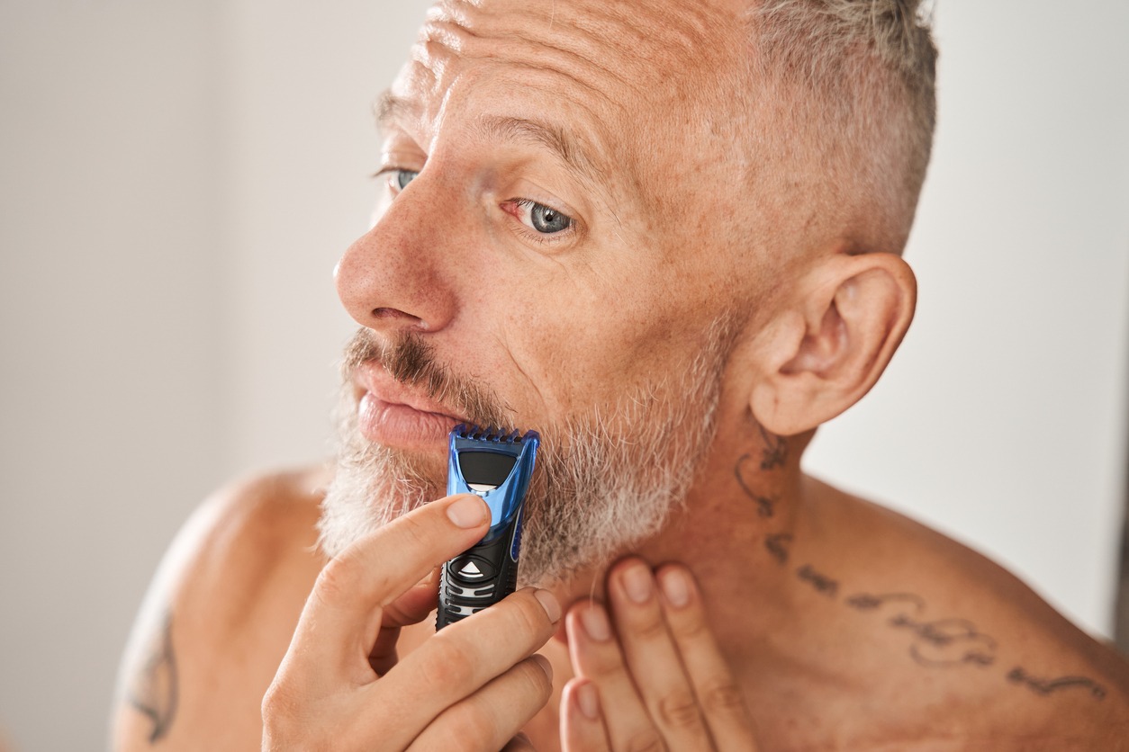 A man trimming his mustache using a trimmer