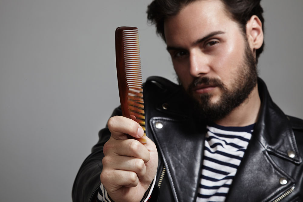 Bearded-guy-in-leather-jacket-holding-comb