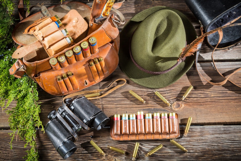 Deer hunting background with hunting gear and apparel on a rustic wooden background with copy space