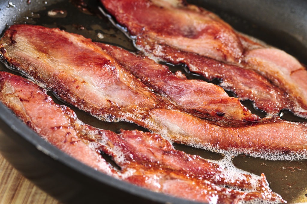 Sizzling bacon on a pan 