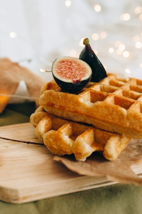 Waffles on a wooden board with sliced fruit