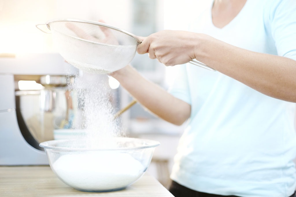  Woman sifting flour and baking in the kitchen