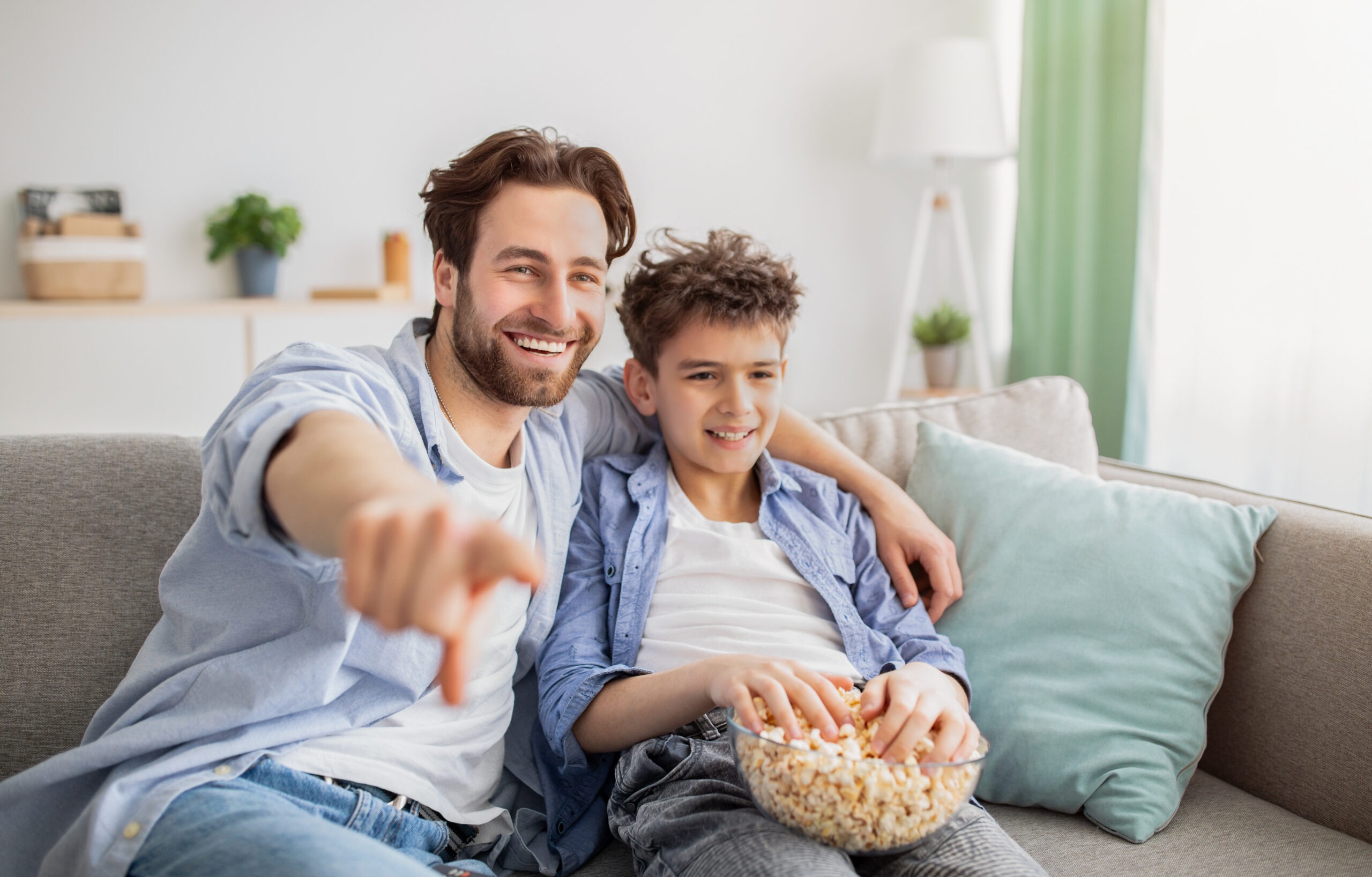 a picture of father and son watching movie at home