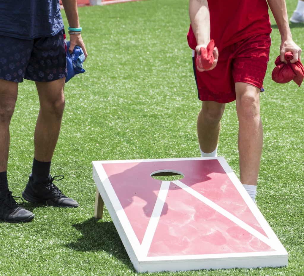 Two boys playing corn hole