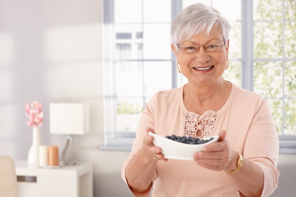 Elderly lady with bowl of blueberry