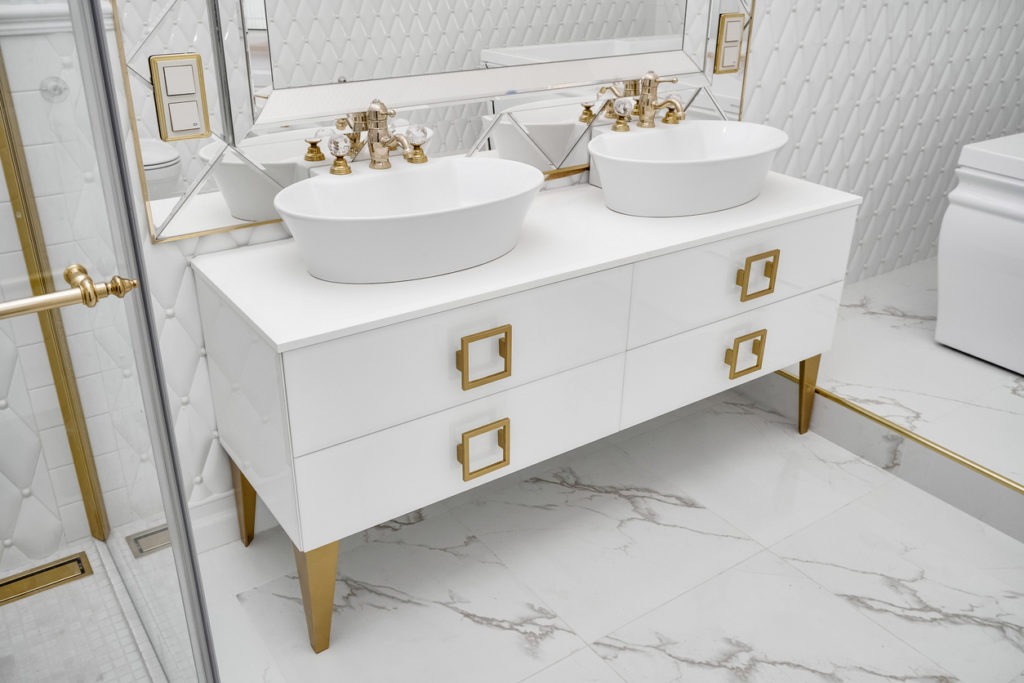 Elegant cabinet with vessel sinks by mirror in bathroom