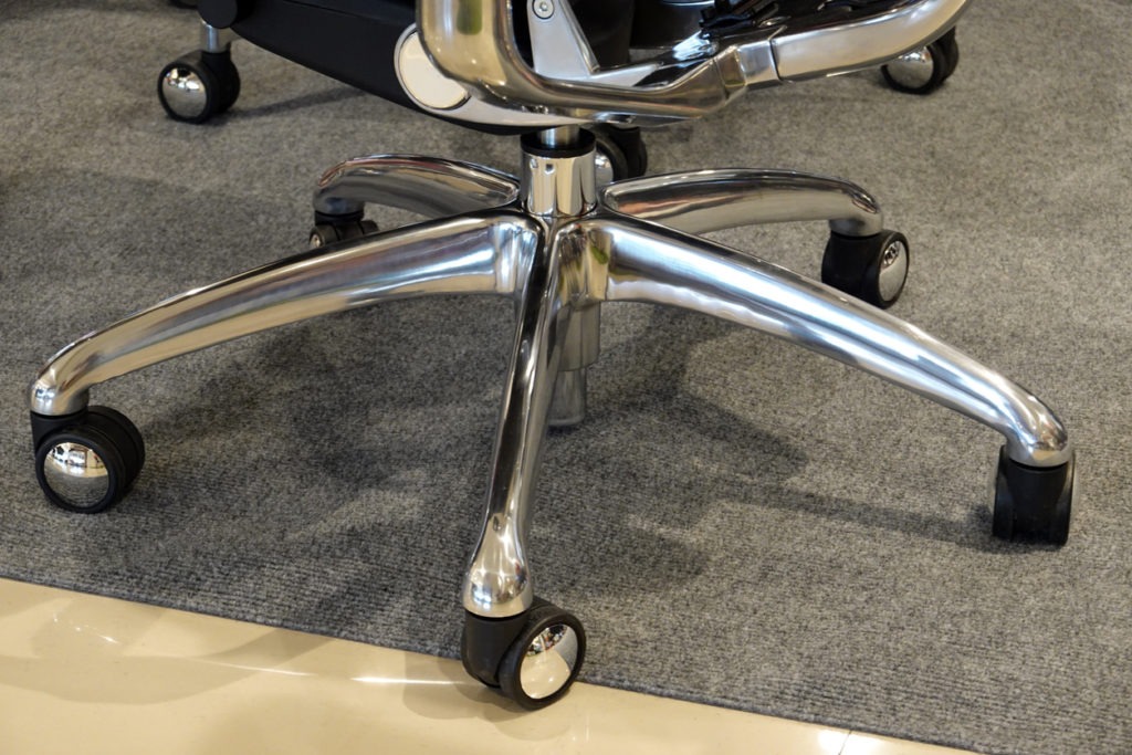 Close up of office chair wheels on the floor in the office. metal legs