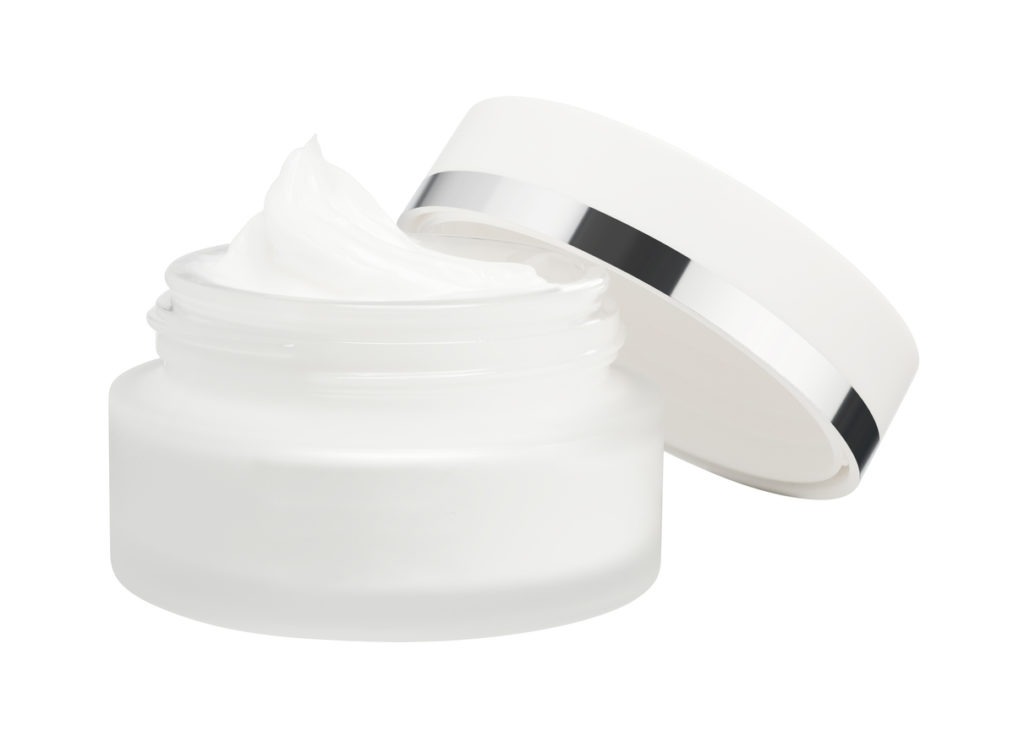 opened face cream container in white background