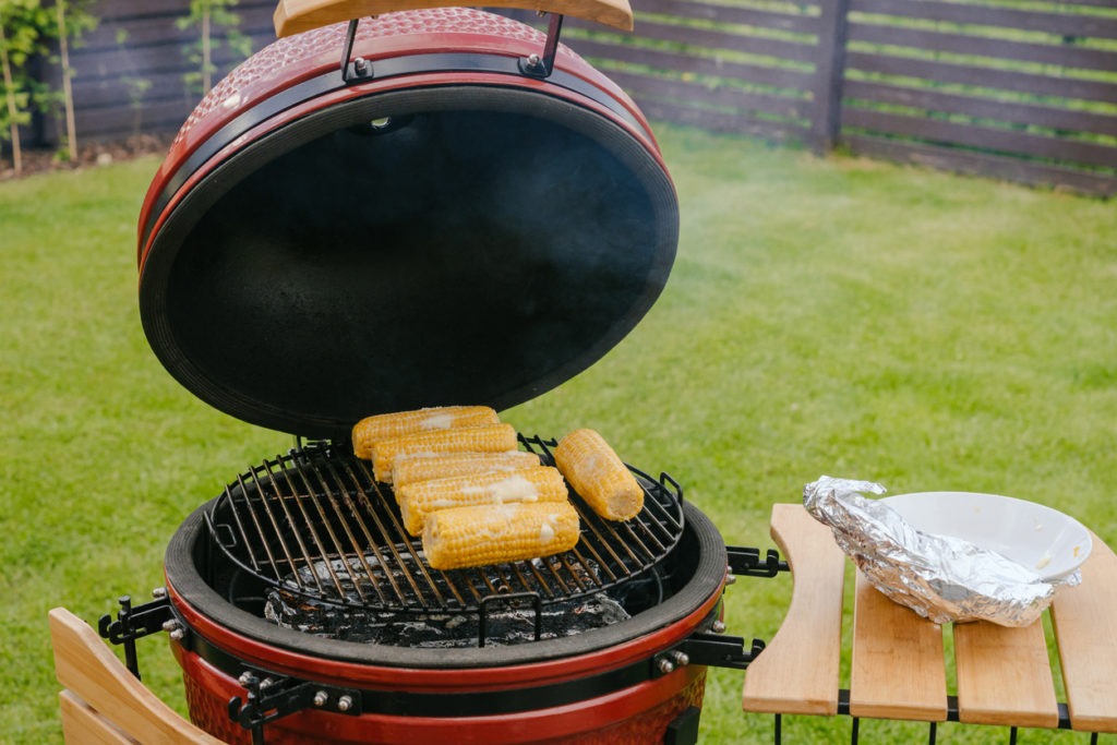 Red Ceramic Barbecue Grill and gourmet veggies - buttered corn cobs