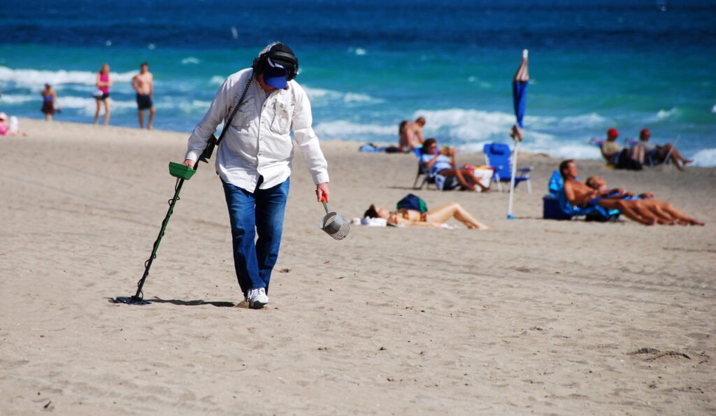 searching the beach with a metal detector