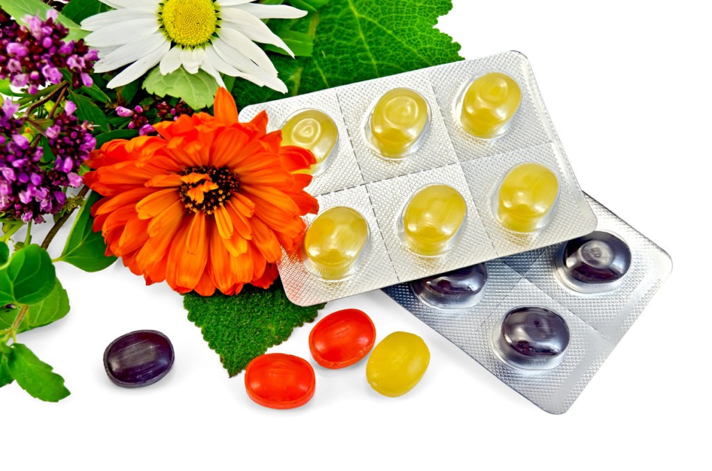 ulticolored lozenges with herbs and flowers in white background