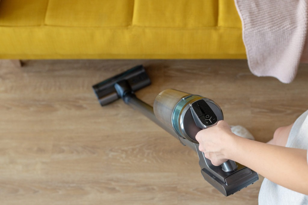 woman holding wireless vertical vacuum cleaner
