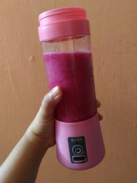 A pink portable blender with smoothie inside