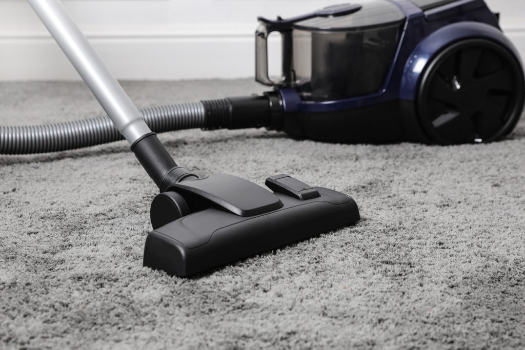 a black vacuum cleaner on gray carpet