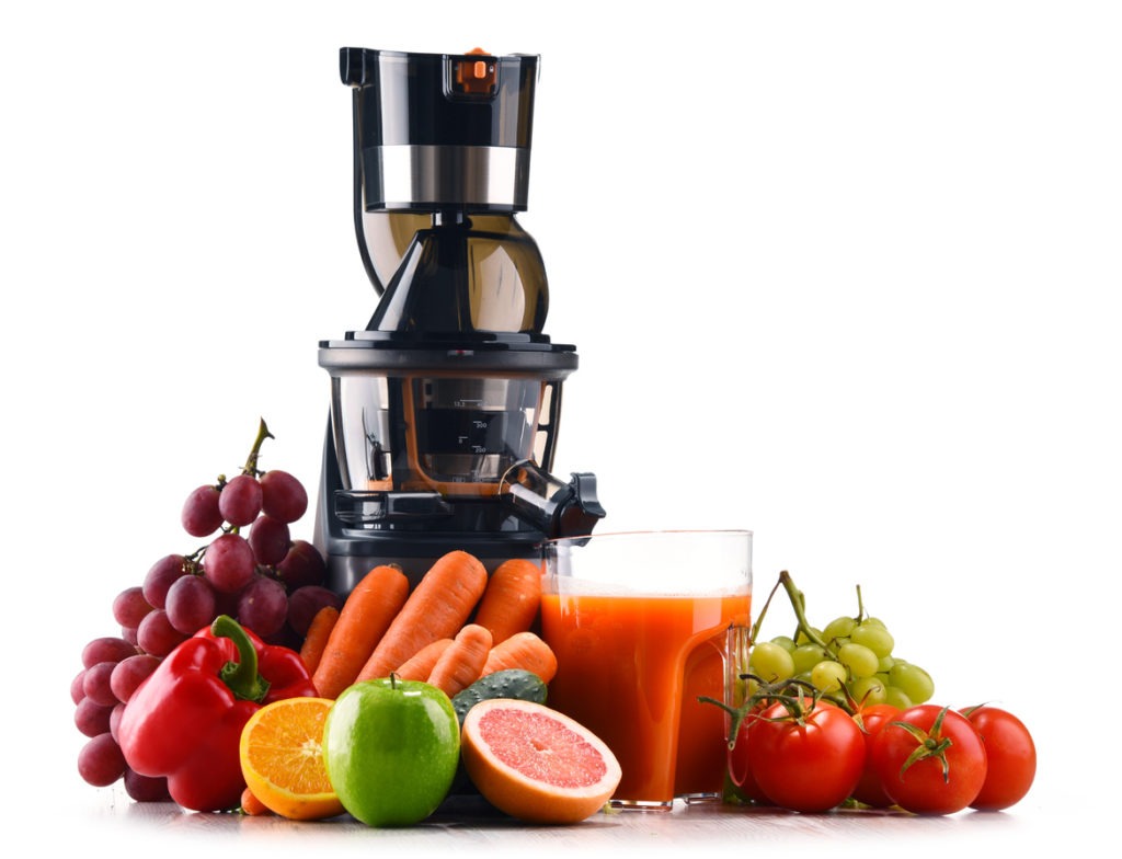 a juicer along with fruits and vegetables