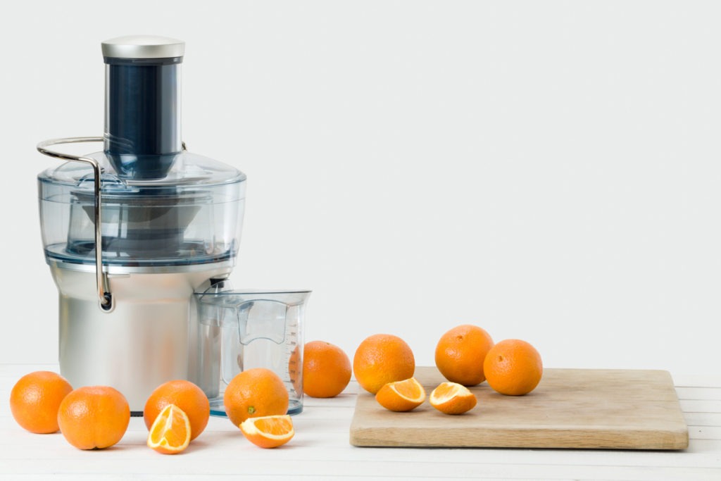 a juicer with fresh oranges