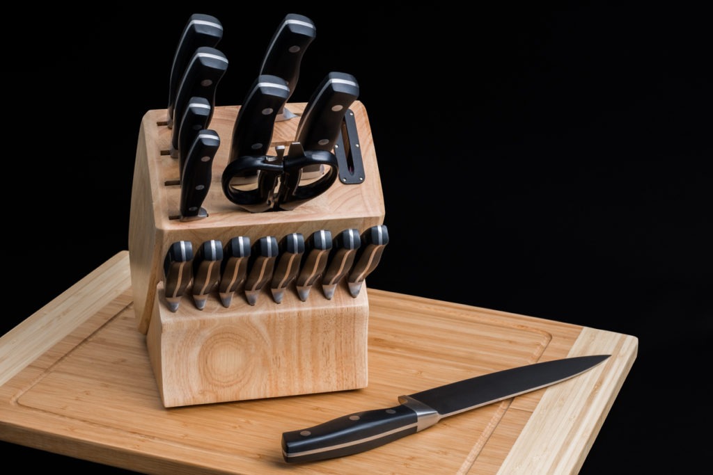 a set of kitchen knives on a chopping board