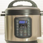 Modern electric multi cooker close up on kitchen table. Up to 1 minutes cooking time remaining