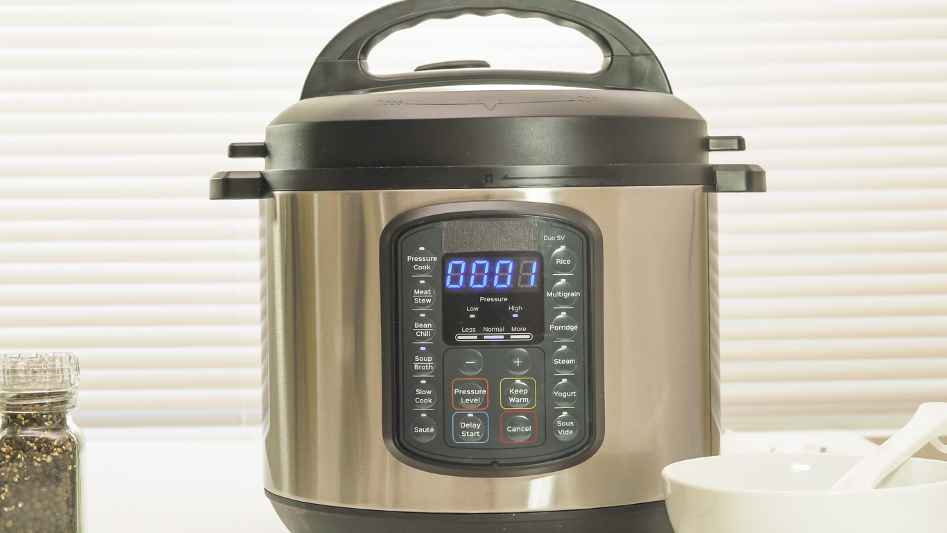 Modern electric multi cooker close up on kitchen table. Up to 1 minutes cooking time remaining