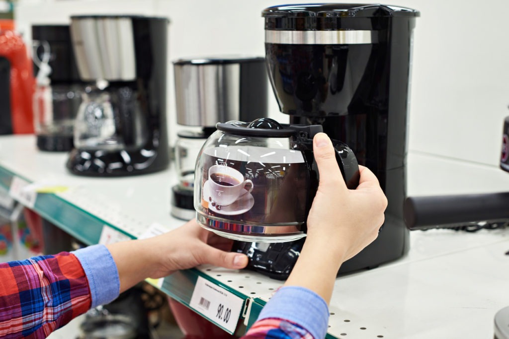 person looking at a coffee maker at a store