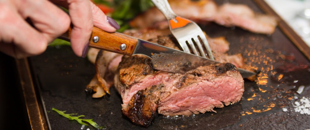 using knife to slice steak