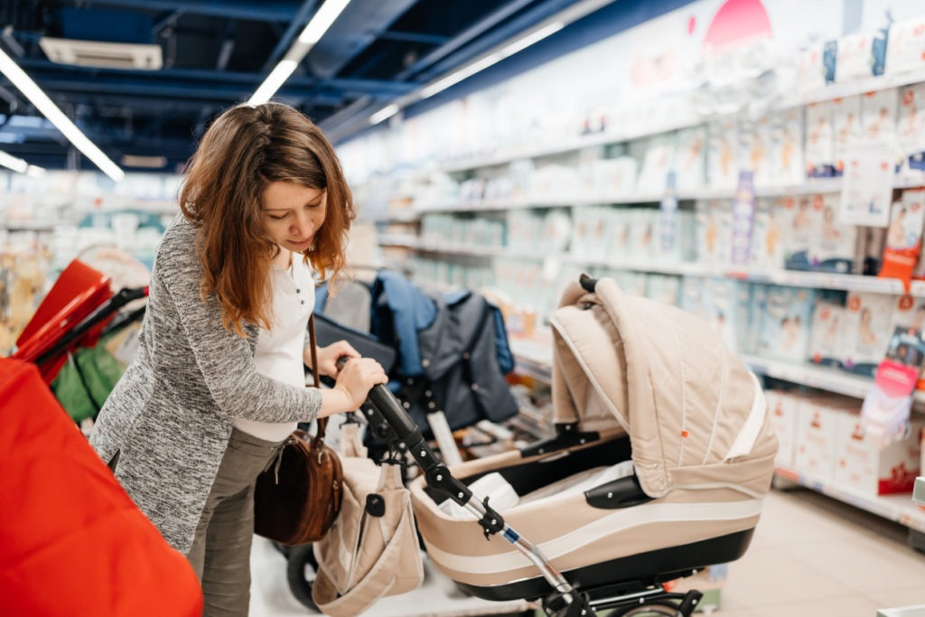 woman checking out a stroller in a store