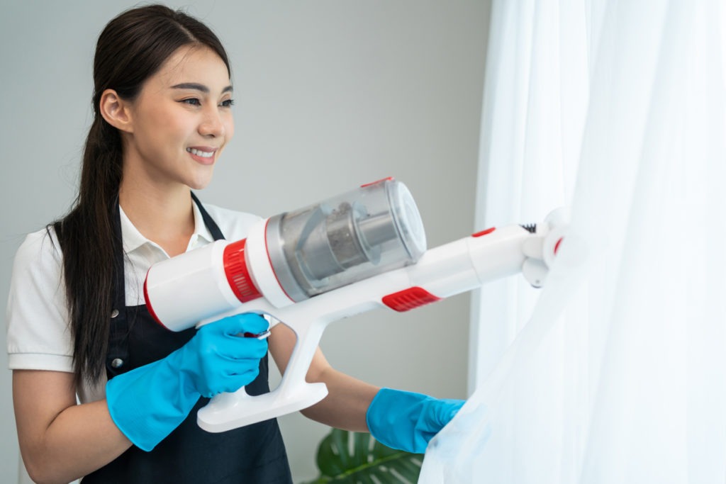 woman cleaning using a handheld vacuum