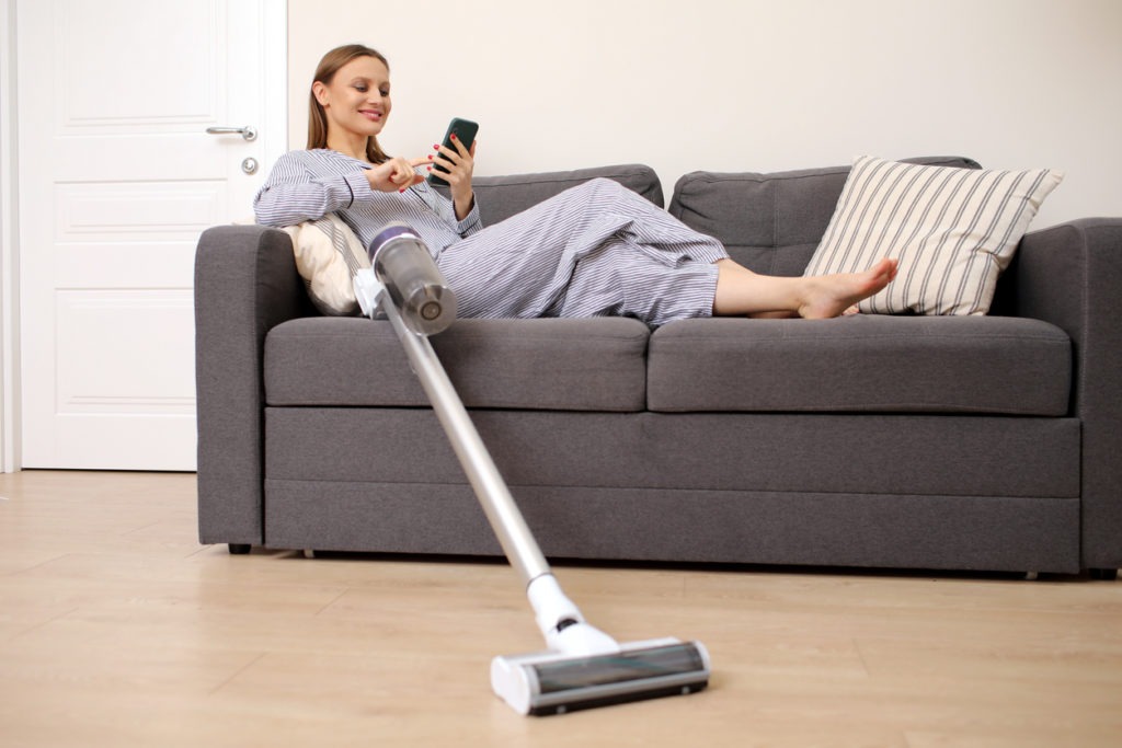 woman with a stick vacuum cleaner