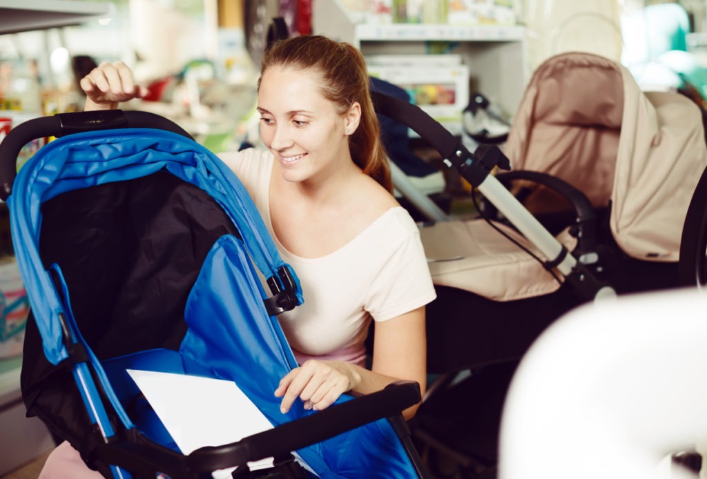 A mother selects a stroller for her baby. 