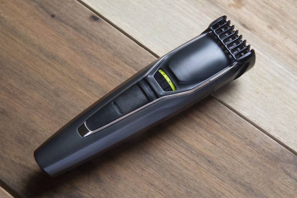 Beard and mustache trimmer on a wooden surface.