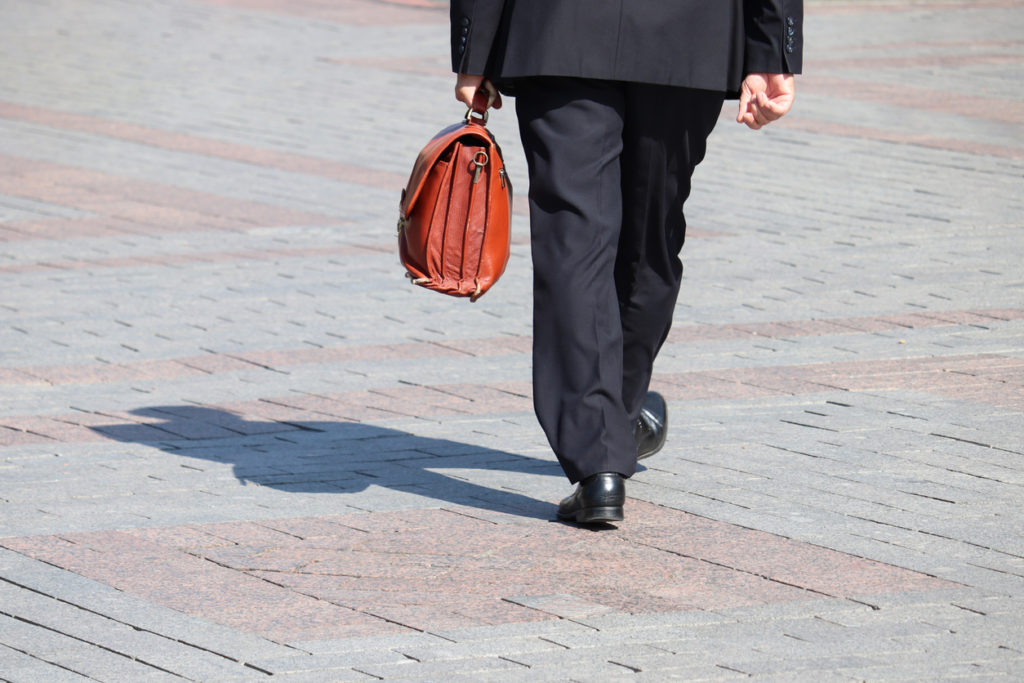 Man carrying a brown leather briefcase. 
