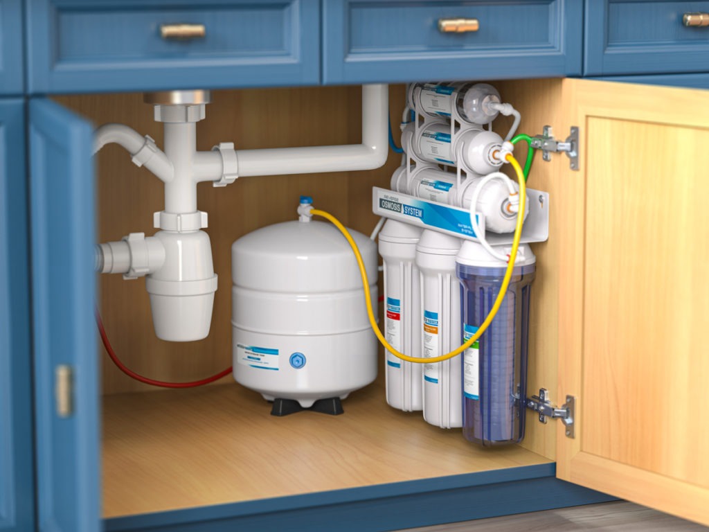 Reverse osmosis water purification system under sink in a kitchen.