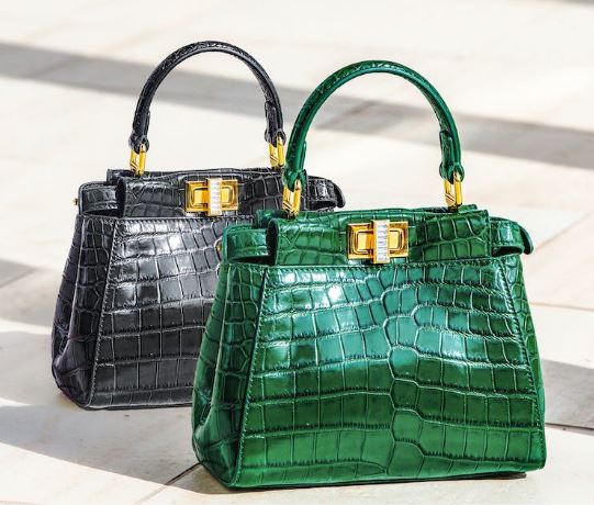 a close up shot of two handbags: one black and one green