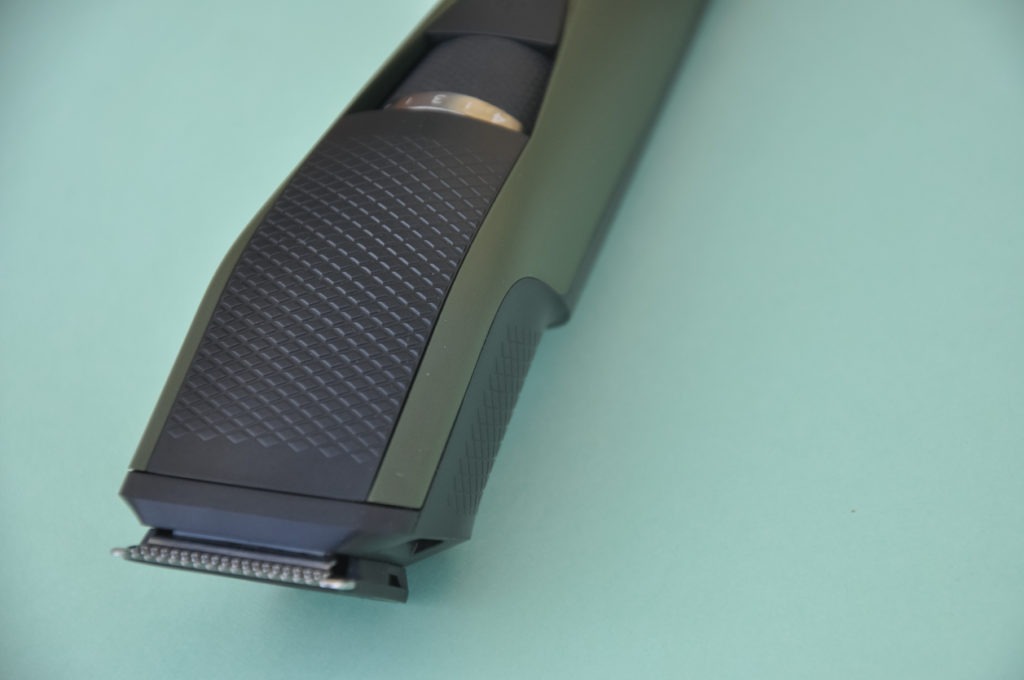 Close up shot of beard trimmer without comb isolated on green background
