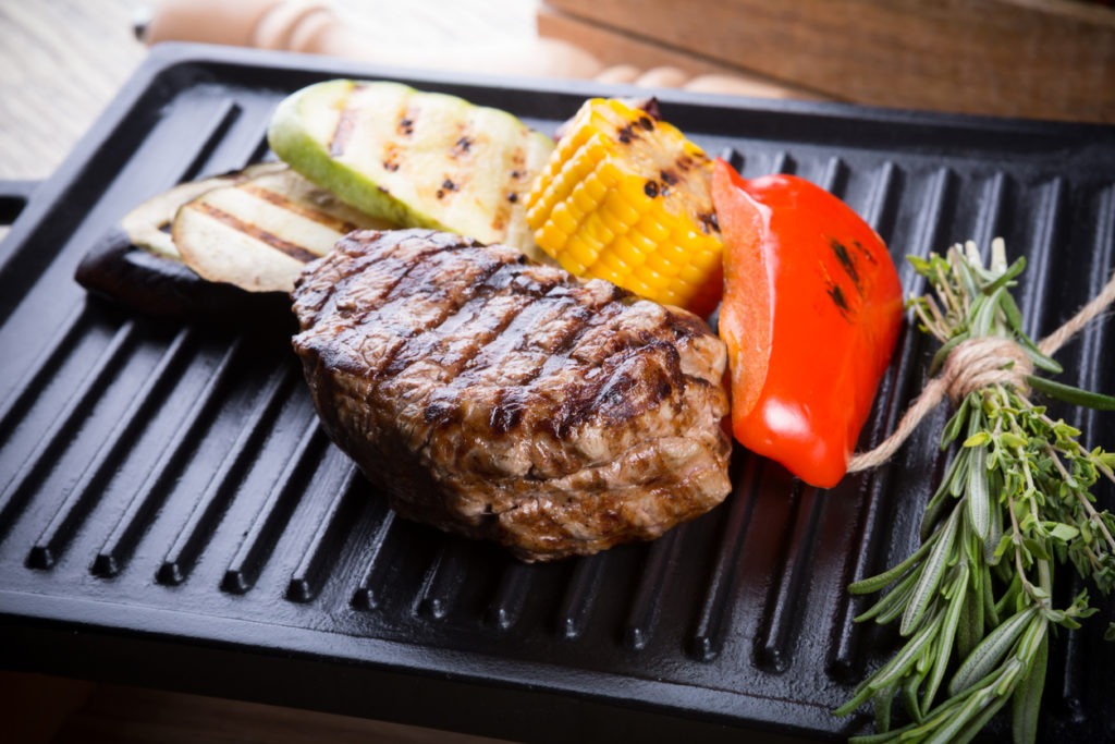 Cooked beef steak on a metal electric grill