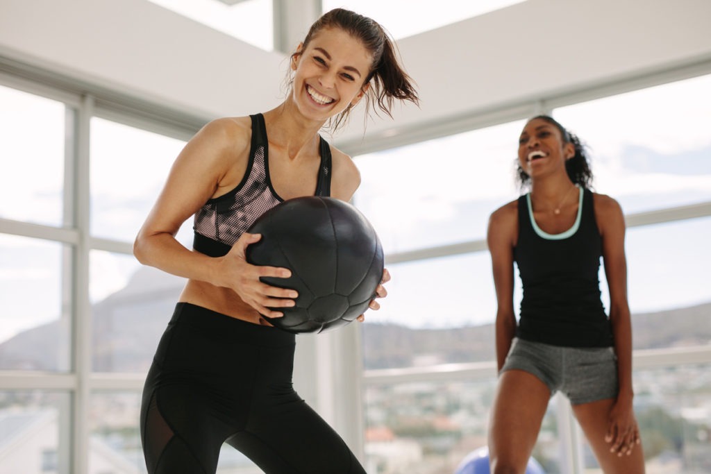 Girls working out in fitness studio with medicine ball
